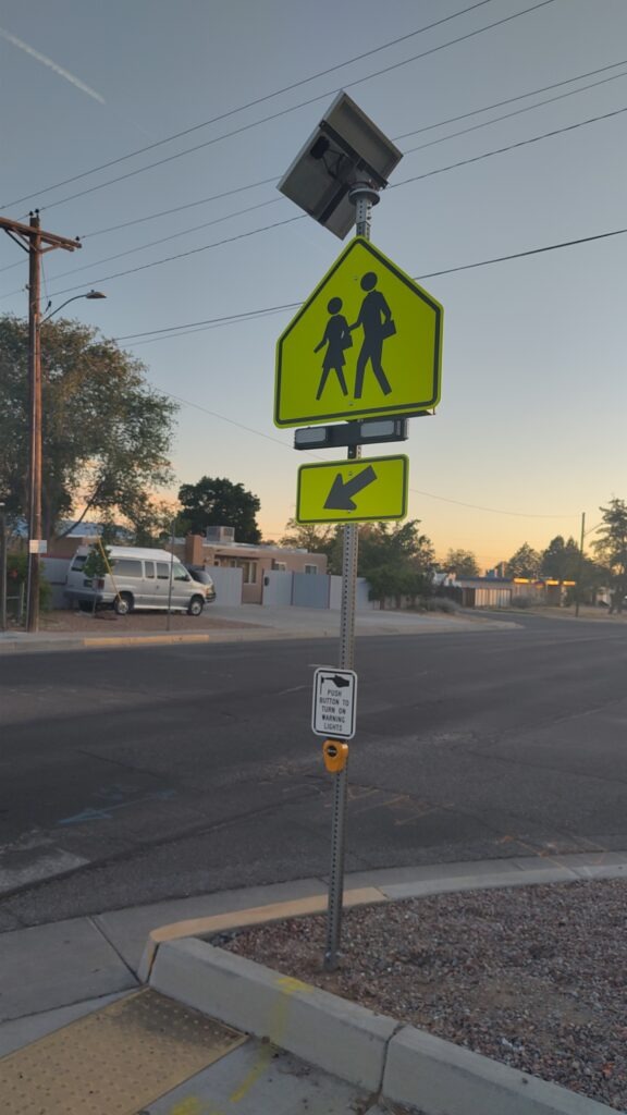 A street crossing with diamond crossing sign on the side of a street.